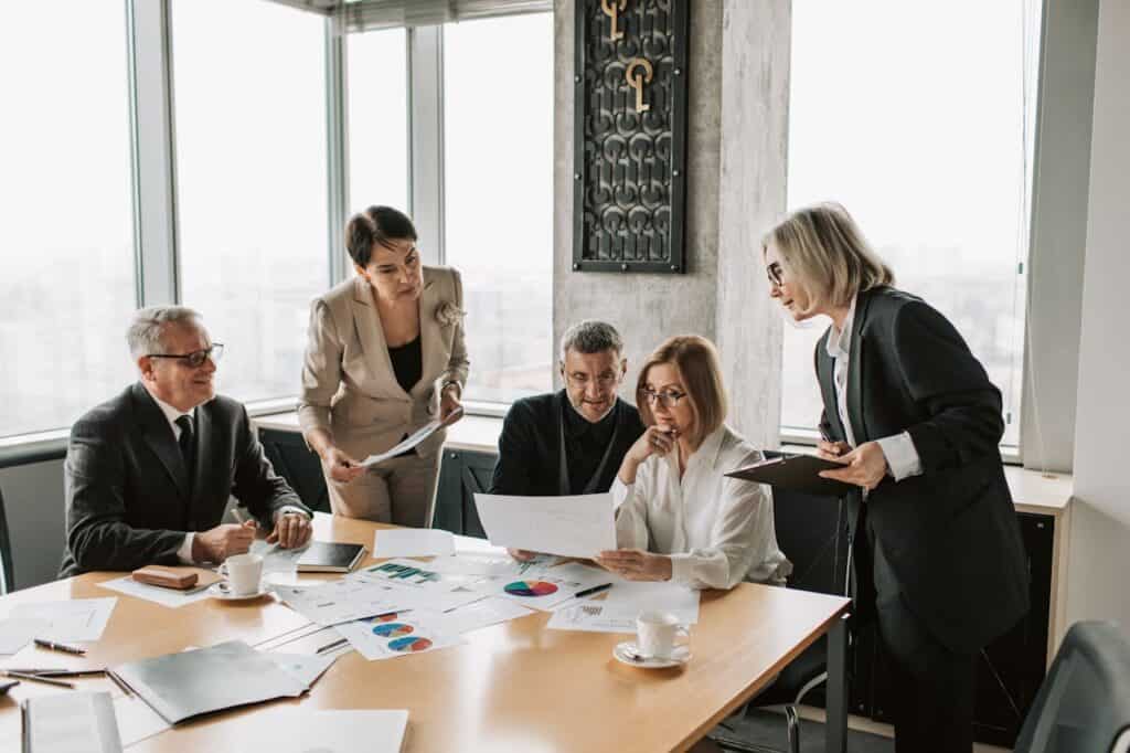 A Group of People Discussing in a Room with Charts and Graphs