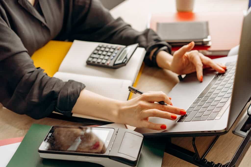 A Person Using a Laptop and Calculator