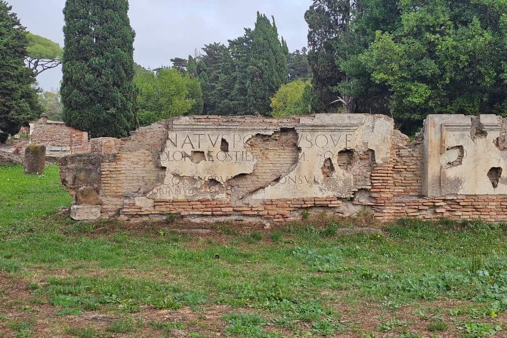 Ancient inscription wall at Ostia Antica, offering insights into Roman history.