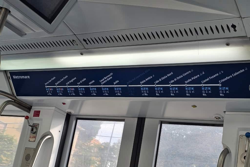 Metromare train route sign inside the Roma-Lido train, showing the full line from Porta San Paolo in Rome to Cristoforo Colombo, including Ostia Antica station.