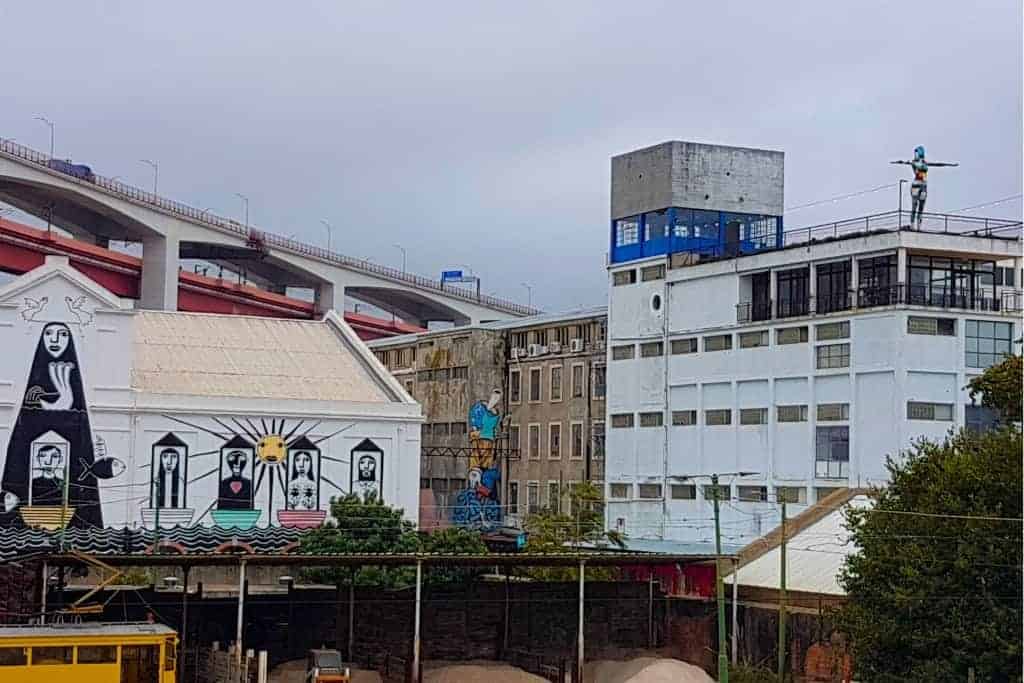 Street art and industrial buildings at LX Factory, a trendy creative hub in Lisbon filled with cafes, shops, and cultural spaces.