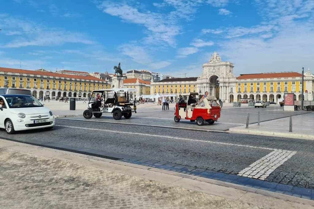 Tuk-tuks and tourists in Lisbon’s iconic Praça do Comércio, an essential landmark on any self-guided Lisbon walking tour.