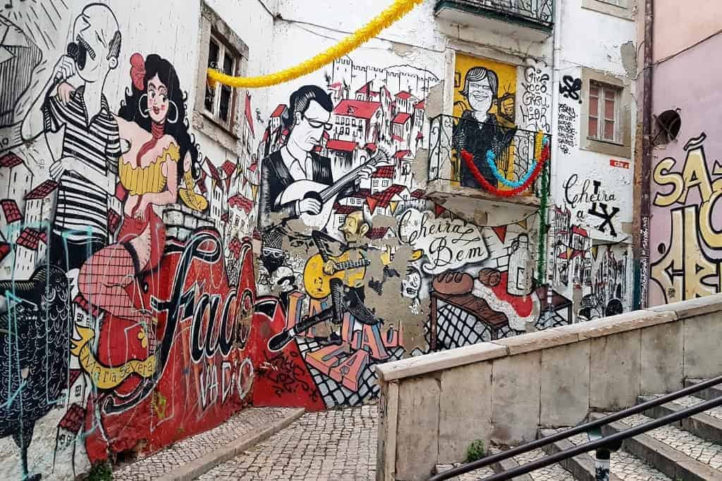 A vibrant street mural depicting Fado musicians in Lisbon’s historic center, a must-see on an urban art walking tour.