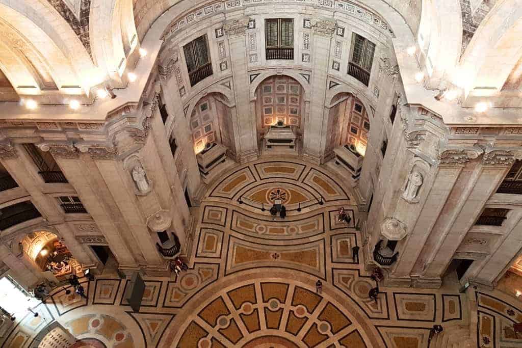 The grand interior of Lisbon’s National Pantheon, featuring intricate architecture, marble floors, and the final resting place of famous Portuguese figures. A top Lisbon travel tip is to climb to the dome for panoramic views.