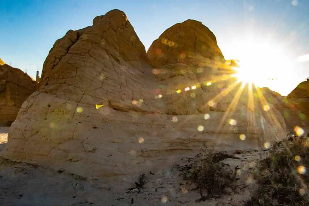 Desert rock formation Dune-of-Sabbia-Dura near Mos Espa in Tunisia with sun flares glowing behind the ridge