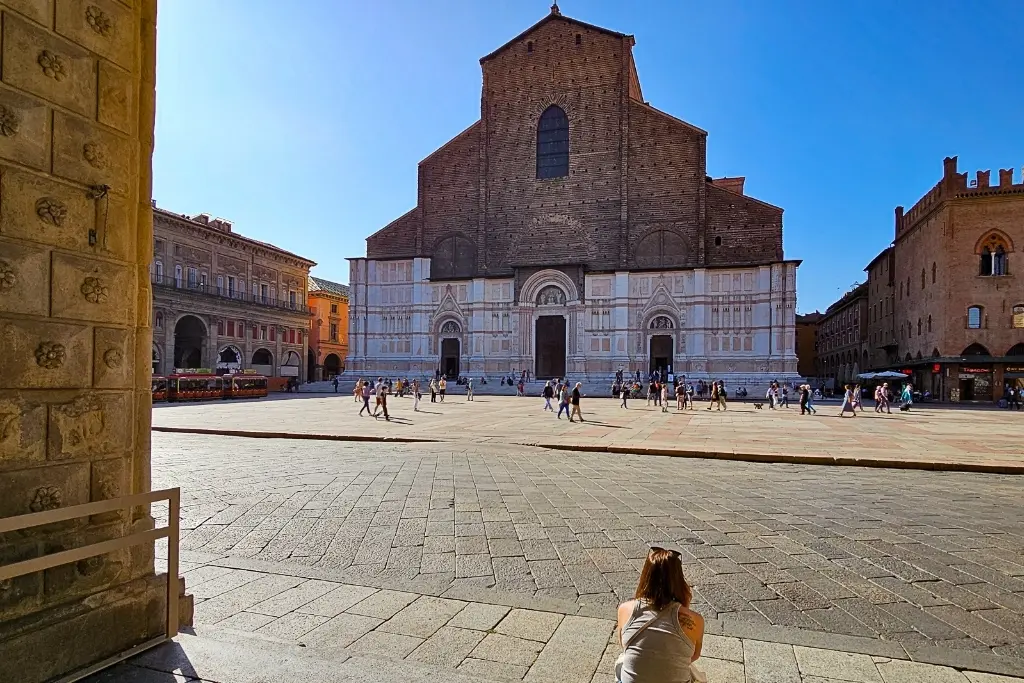 Wide-angle view of the unfinished façade of Basilica di San Petronio on Piazza Maggiore, Bologna’s main square—an essential stop for photographing medieval architecture and local street scenes.