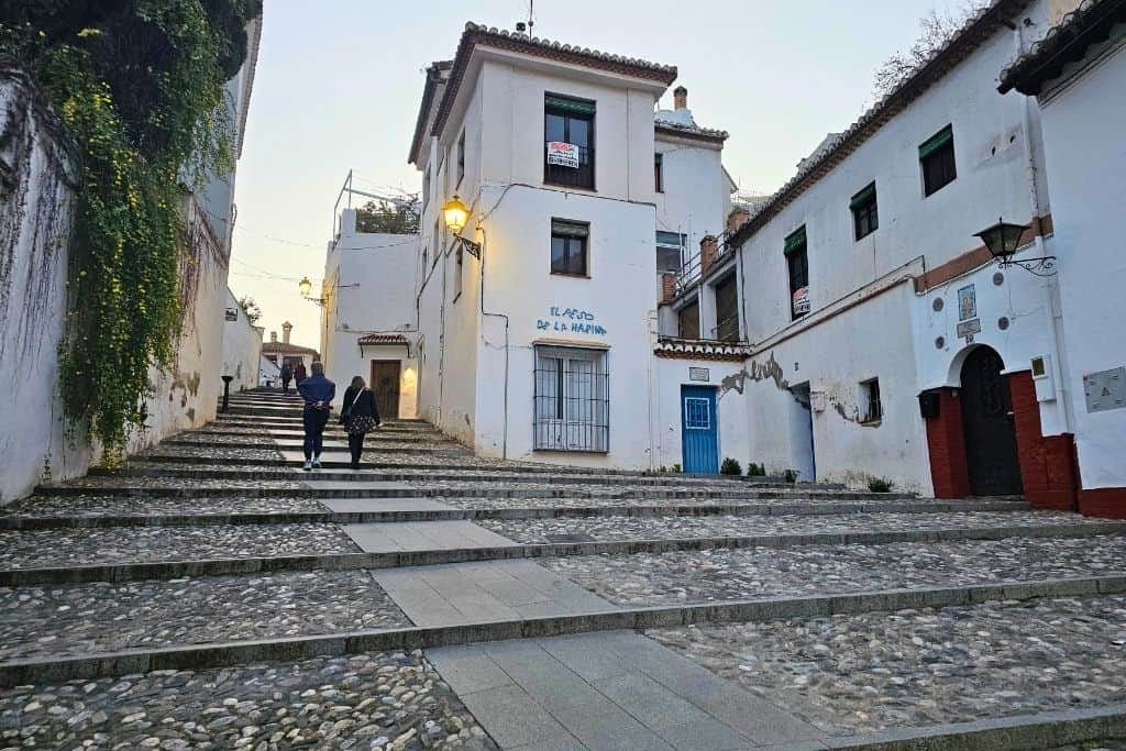 Evening view of Placeta del Peso de la Harina, a charming stepped square in the Albaicín with whitewashed houses and a relaxed, local vibe – a Granada hidden gem worth discovering.
