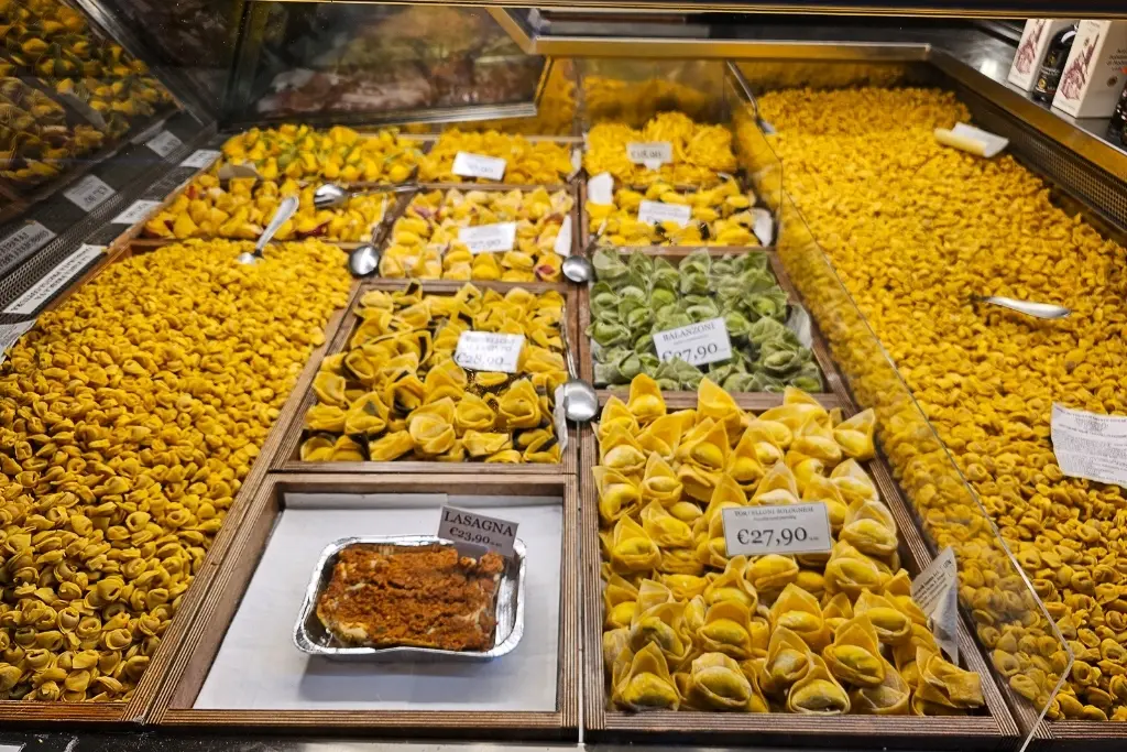 Fresh tortellini and balanzoni at a pasta shop in Bologna’s food district—unmissable if you're searching is Bologna worth visiting for cuisine.