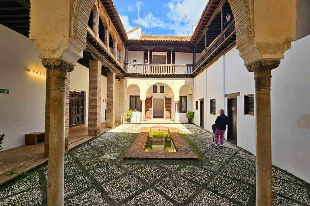 Traditional Andalusian courtyard of Casa de Zafra in the Albaicín district of Granada, featuring Moorish arches, whitewashed walls, and a reflecting pool—one of the top hidden gems to explore in Granada, Spain.