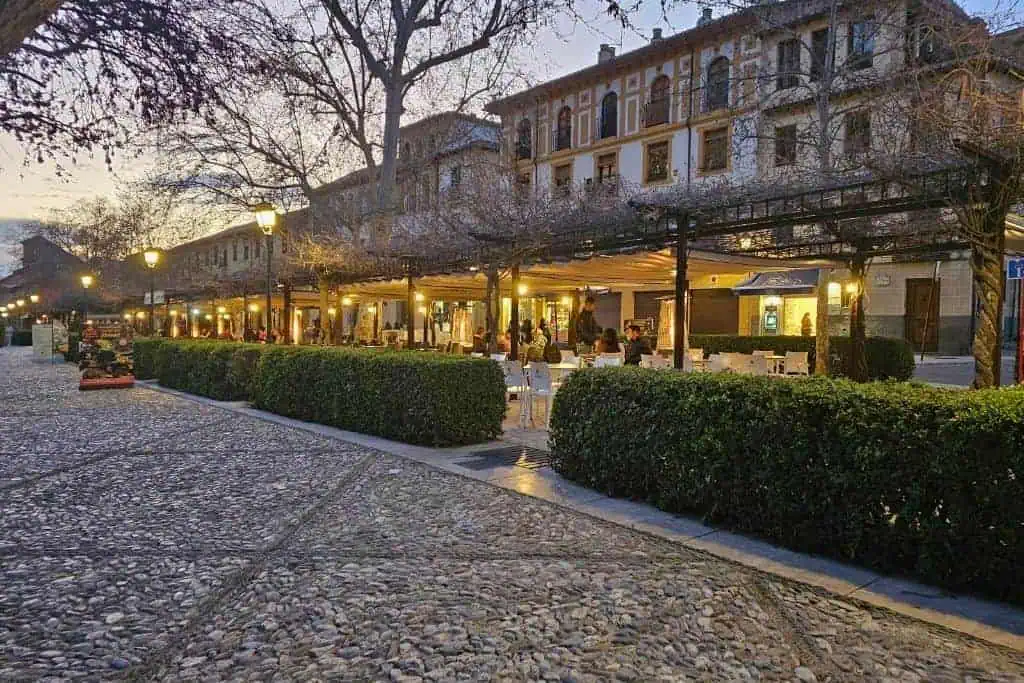 Twilight scene of Paseo de los Tristes in Granada, a romantic riverside promenade with views of the Alhambra and cozy cafes – ideal for an evening stroll.