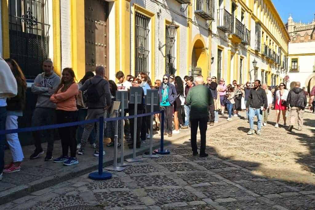 Close-up of visitors queueing outside Seville’s Real Alcázar, illustrating how walk-up ticketing leads to long wait times — one of the top tourist mistakes in Seville.