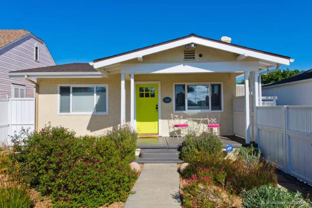Cream-colored bungalow at 3321 Felton Street in North Park with a bright lime green front door, a front porch with bistro seating, and drought-tolerant landscaping.