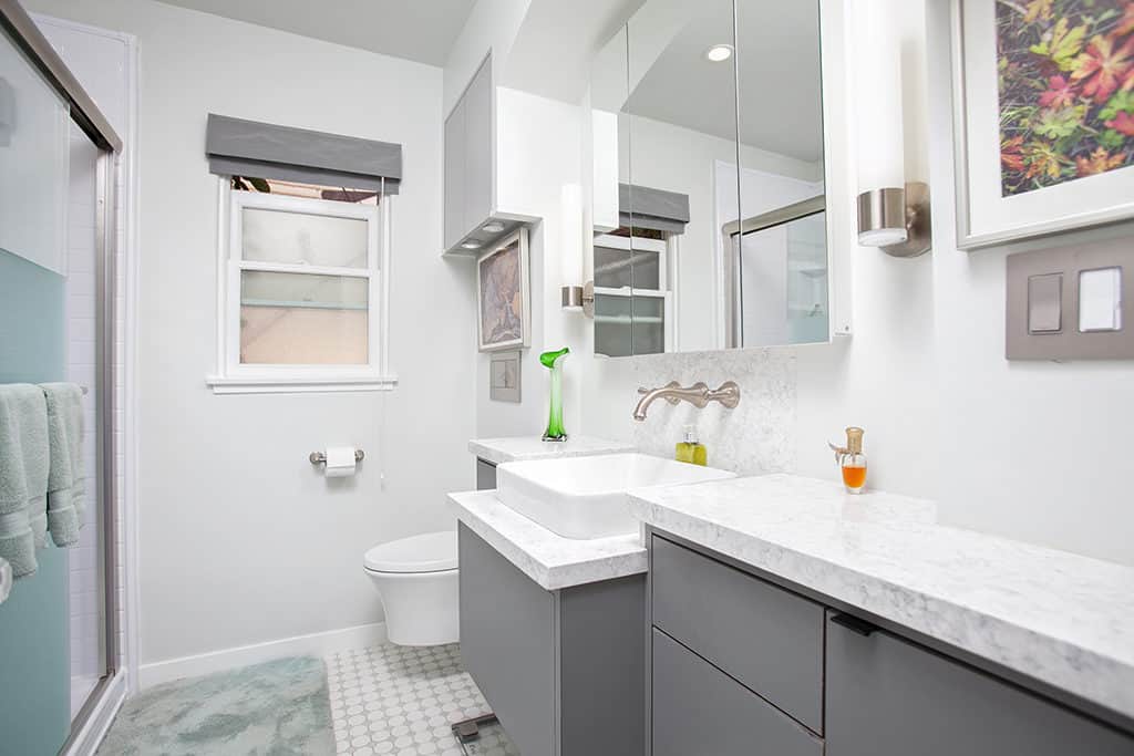 Modern bathroom at 3317-3319 Boundary Street in North Park featuring a grey floating vanity with a marble countertop, white vessel sink, and penny tile flooring.