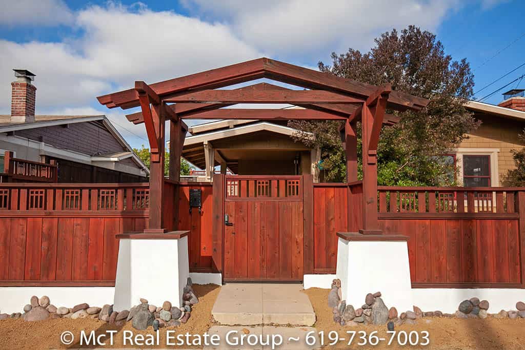 Close-up of the Craftsman redwood gate and detailed arbor entry at 3044 29th Street in North Park, accented by white stucco pillars and desert landscaping.