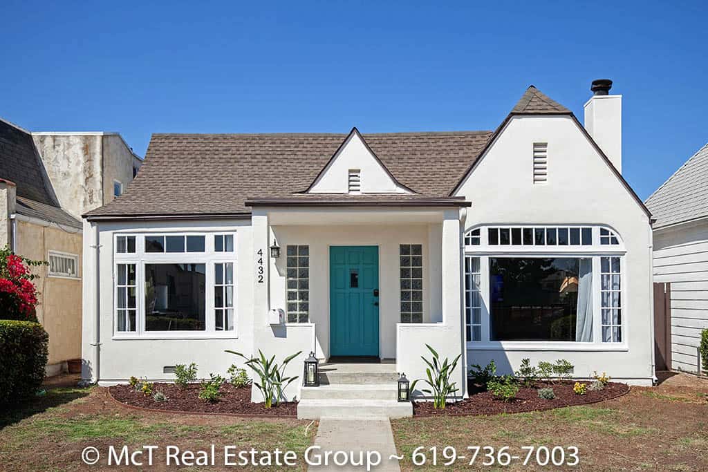 Tudor-style cottage at 4322 38th Street in Normal Heights featuring a bright turquoise front door, white stucco exterior, asymmetrical gabled roofline, and multi-pane windows with a freshly landscaped front yard.