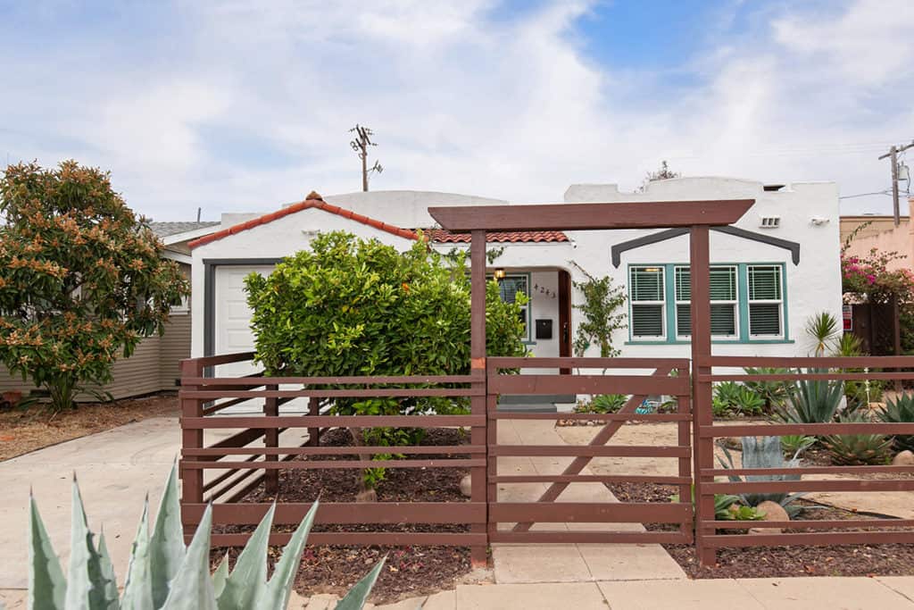 wood fence in front of landscape and front of house