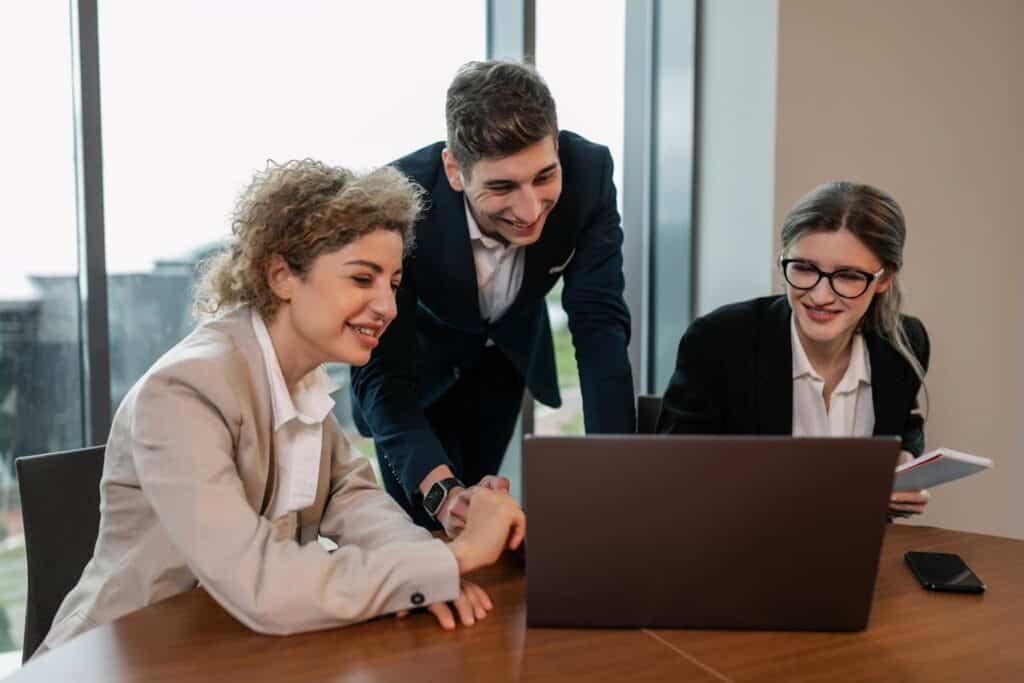 A Group of Colleagues discussing Something infront of a Laptop