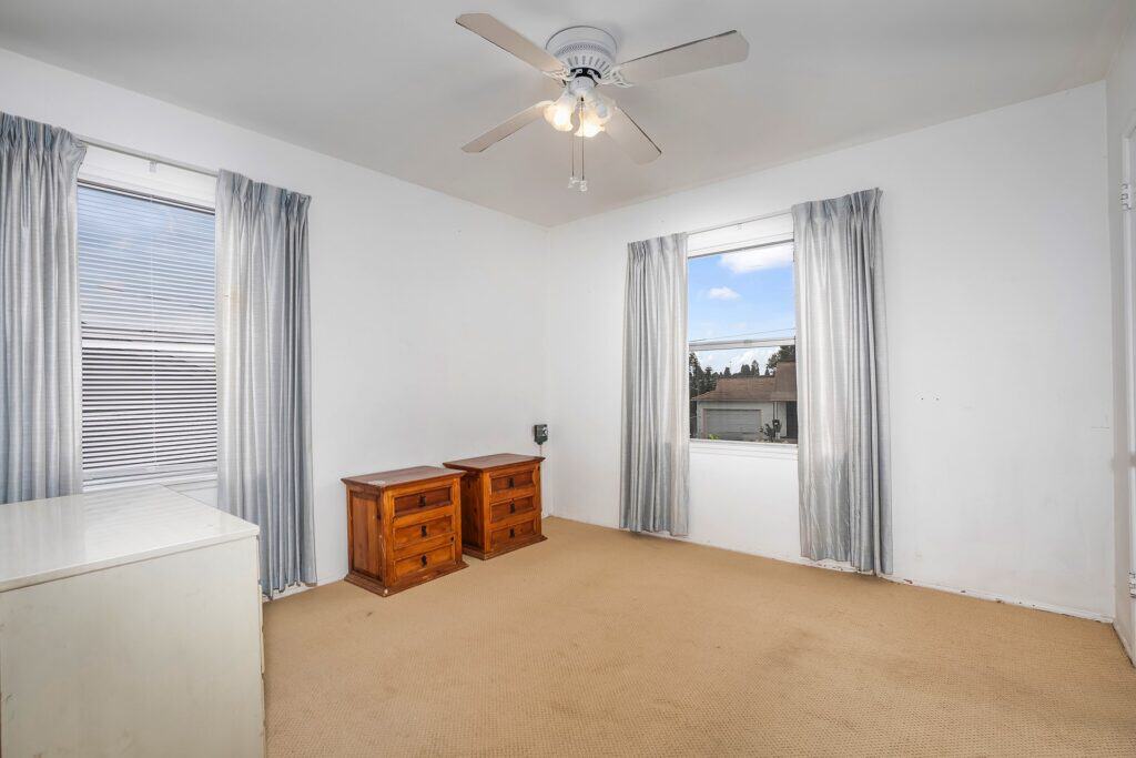 Third bedroom at 1751 39th St, San Diego, with dual windows and original wood dressers, perfect for an office or guest room