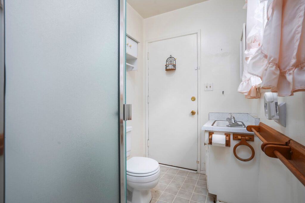Clean 1.5 bath layout at 1751 39th St, San Diego, showcasing tile flooring and a frosted glass shower door