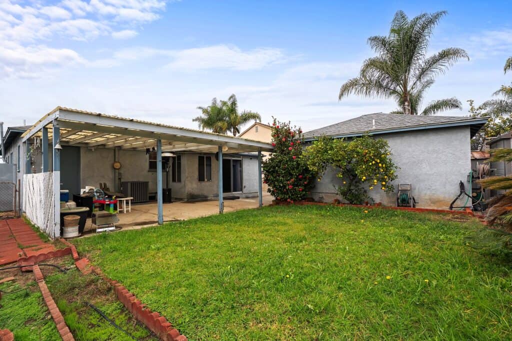 Full backyard view of 1751 39th St, San Diego, including a storage shed, garden beds, and mature fruit trees.