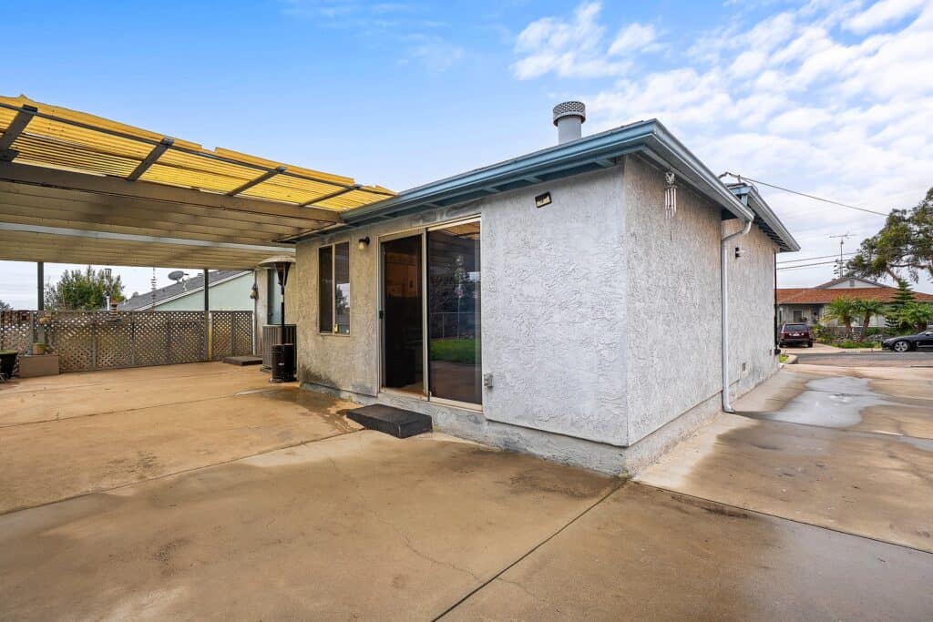 Rear exterior view of 1751 39th St, San Diego, showing the sliding glass door and concrete driveway access