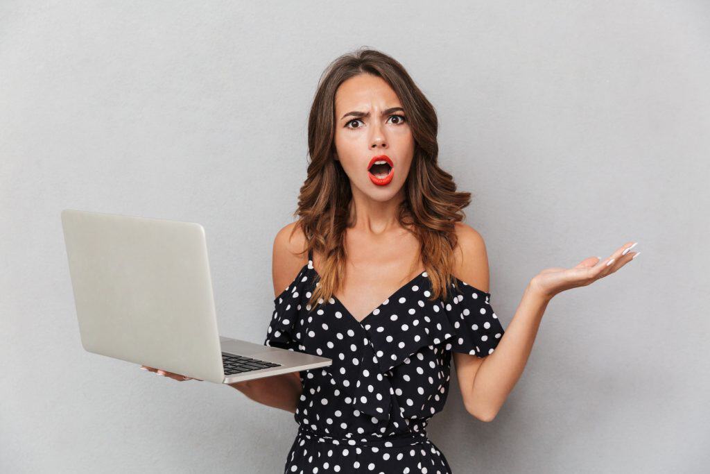 Woman holding a laptop wondering how to find love online.