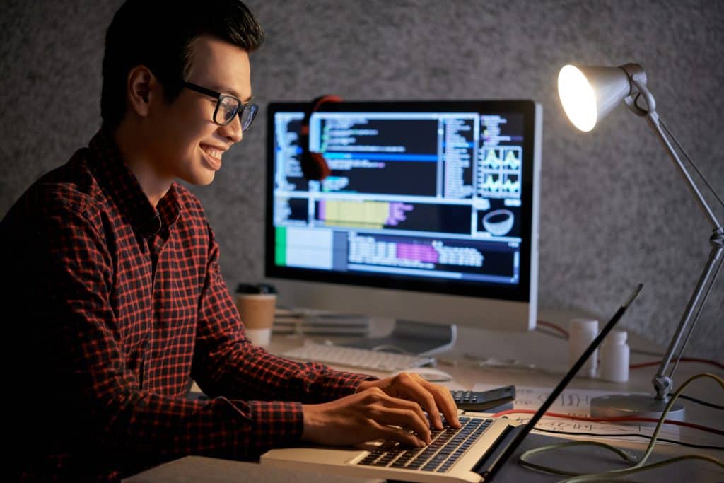 Engineer smiling as he interacts with someone on an online dating site.