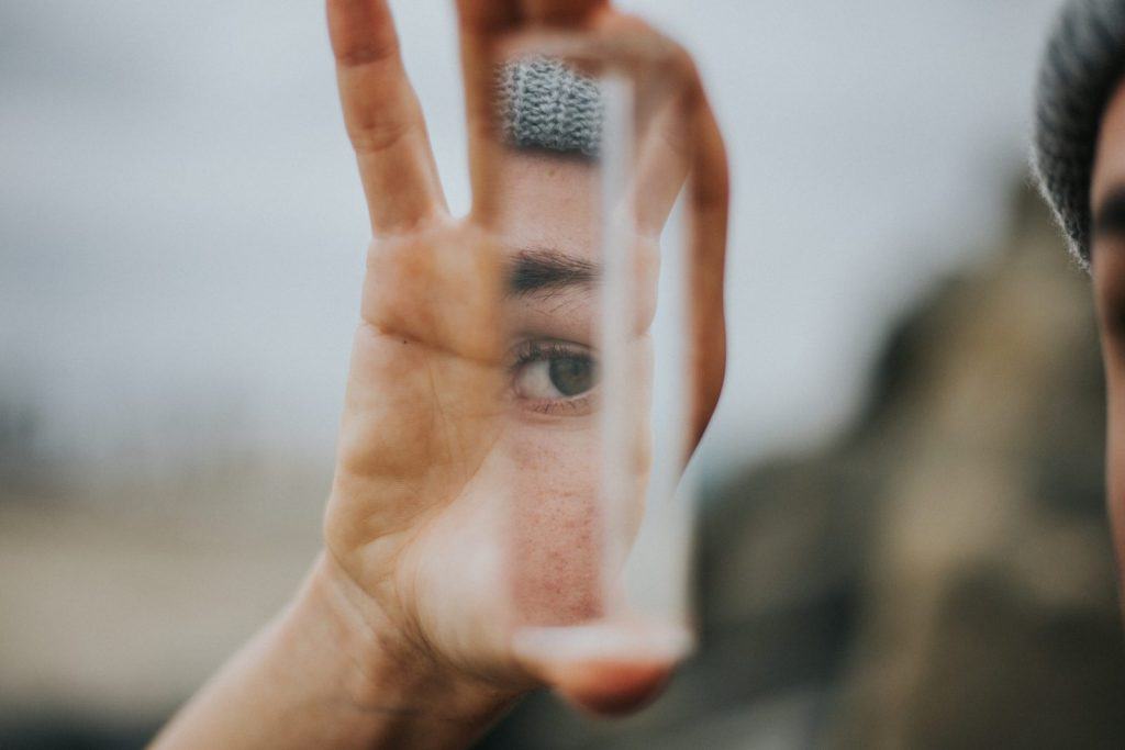 curious person holding a mirror prism