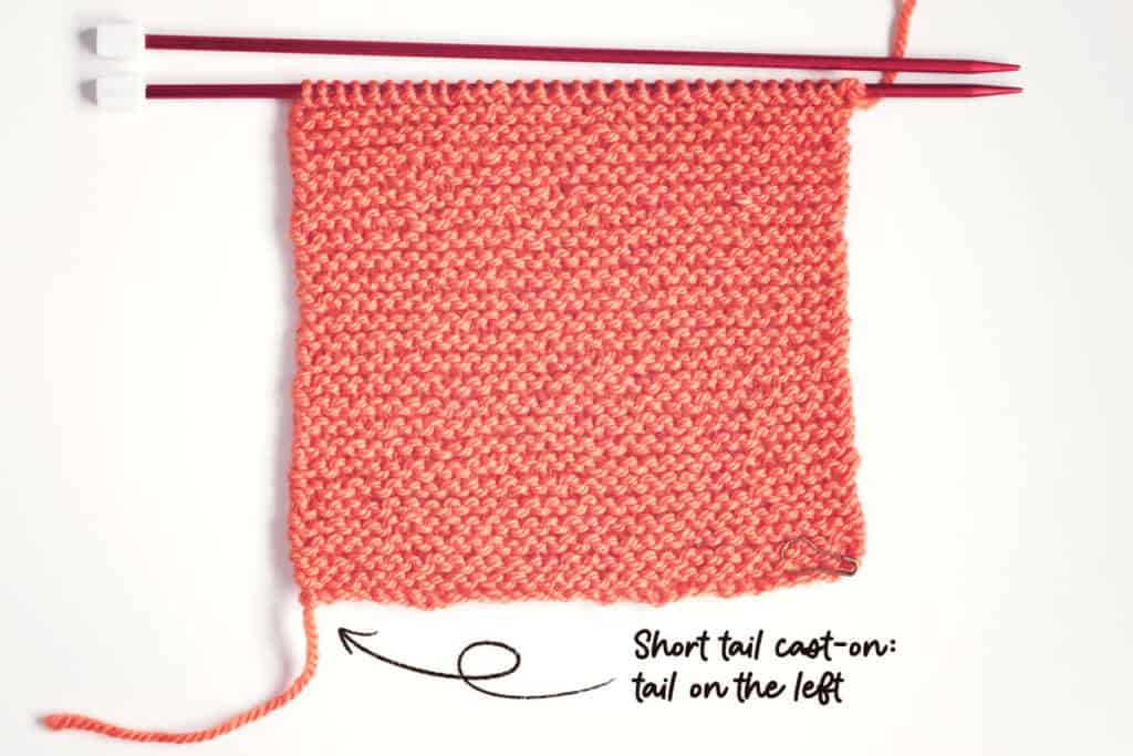 orange garter stitch swatch made with a short tail cast-on, showing that when the right side is facing the yarn tail is on the left-hand side