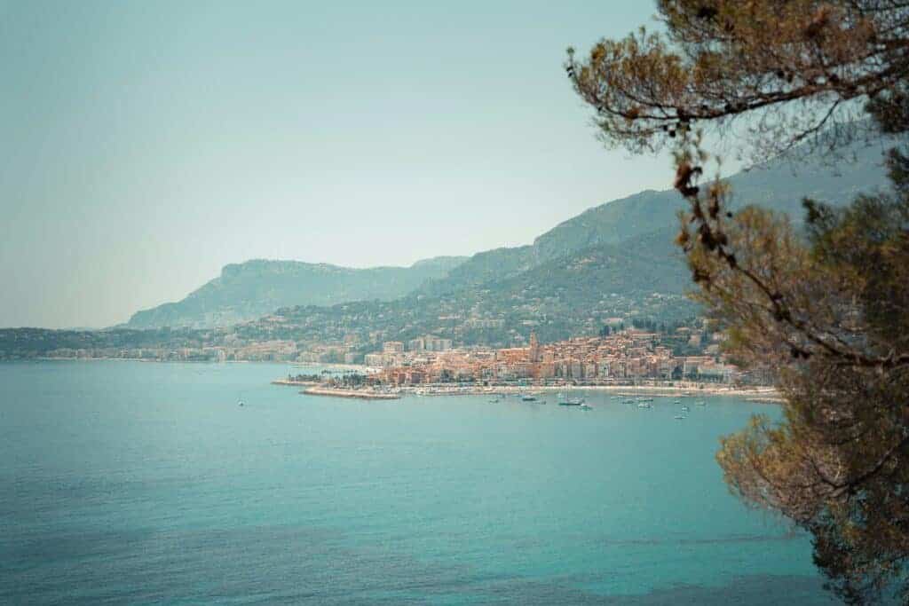 Menton coastline with turquoise sea, colourful town and mountains beyond