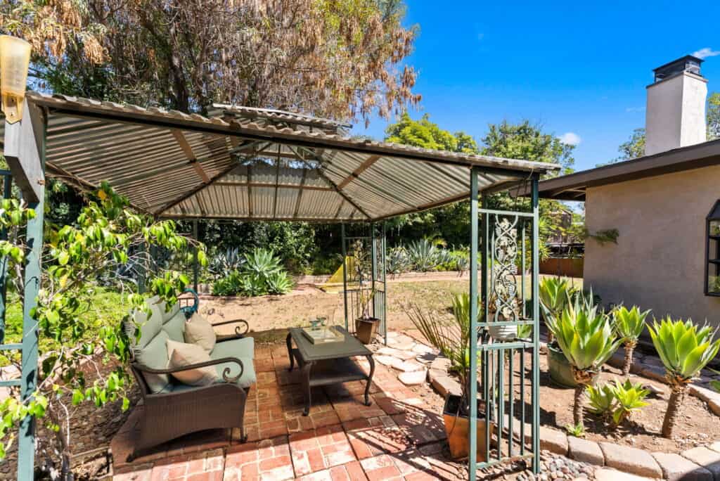 side of home with outdoor seating under pergola