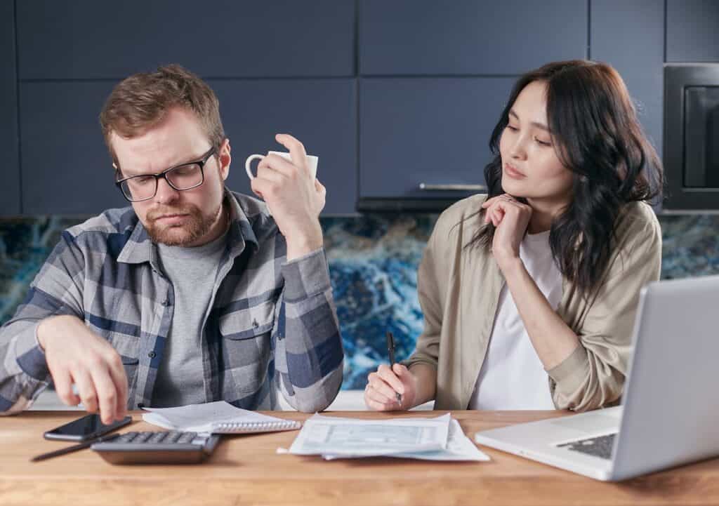 A Couple Discussing with Paperwork and a Calculator