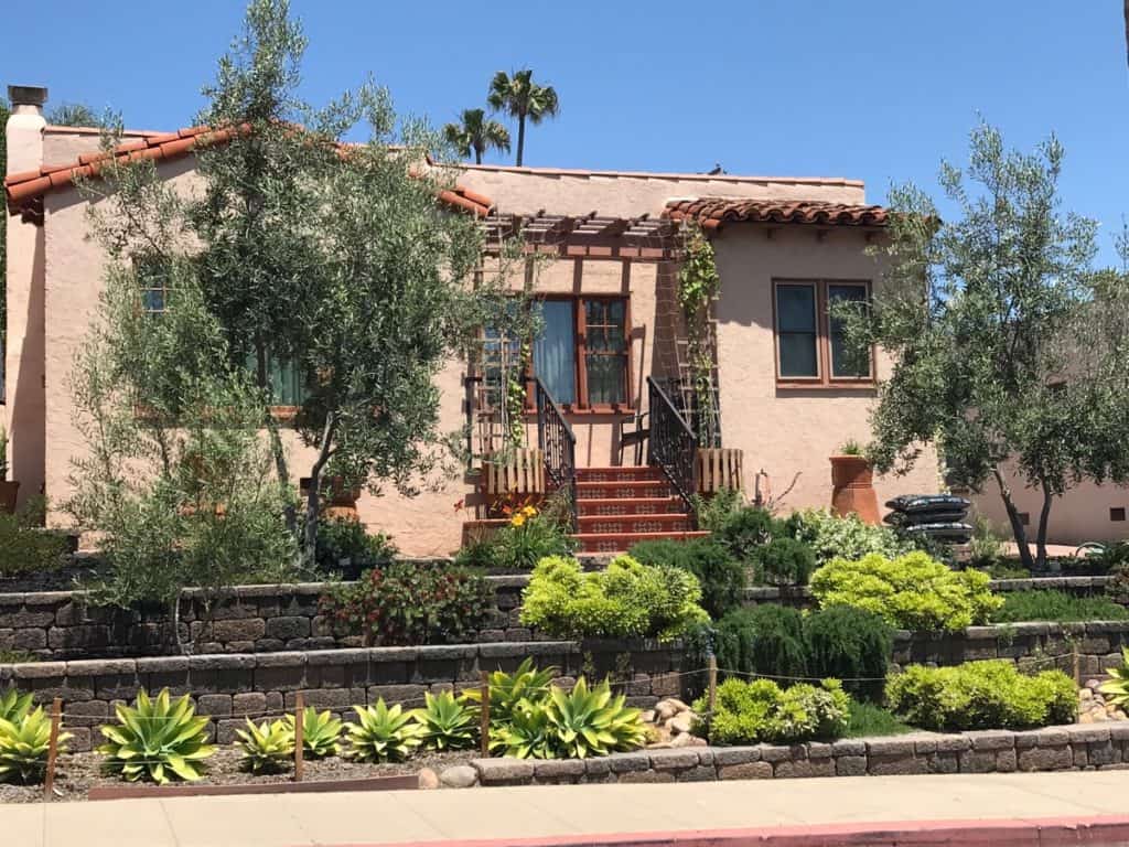 Charming Spanish-style duplex at 3317-3319 Boundary Street in North Park, featuring a classic terracotta tile roof, a tiered front yard with professional drought-tolerant landscaping, and an inviting entry porch with a decorative wood pergola.