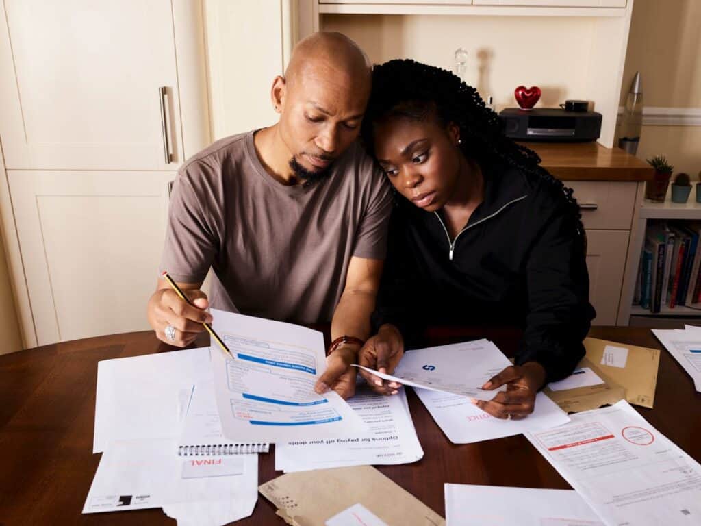 A Couple Sitting by the Table Looking Over Bills