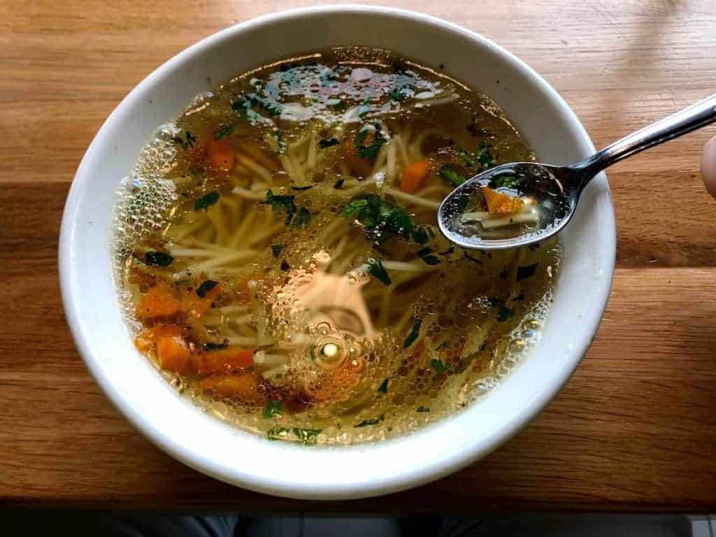 Polish chicken rosol soup in a white bowl.