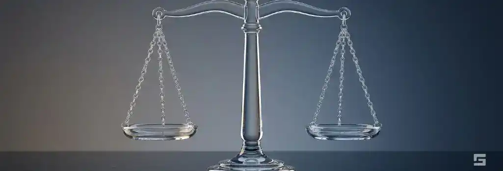 Clear glass Scales of Justice on a navy and slate background, weighing the value of a personal injury lawsuit. Grano Law Offices, P.C. injury representation.