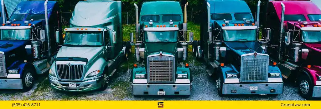 Five large, colorful semi-trucks parked in a row, representing the commercial trucking industry, with Grano Law Offices branding.