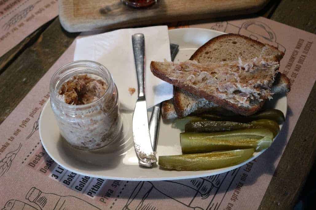 A plate of Polish food with bread and pickles.