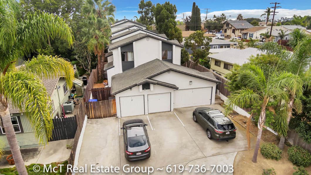 Aerial view of a multi-unit residential complex featuring white stucco exteriors, dark trim, and multiple garage bays at 3711 Louisiana Street in North Park.