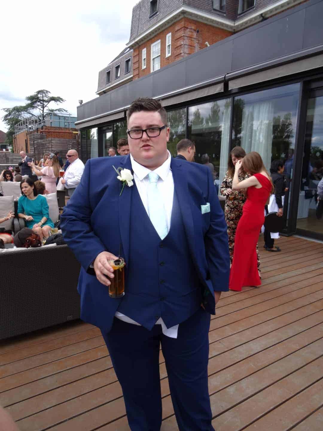 A person in a suit standing in front of a building