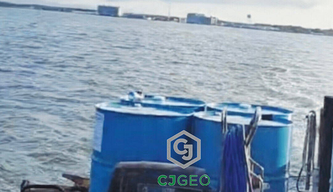 Logistics for a remote project: Grouting materials in blue drums transported by boat across the water to Tangier Island.