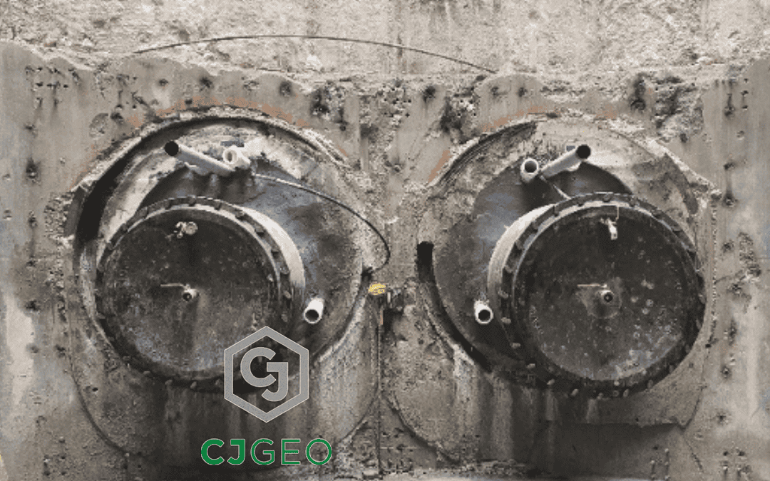Two ductile iron water intake pipe protruding from tunnel casings inside of a shaft.