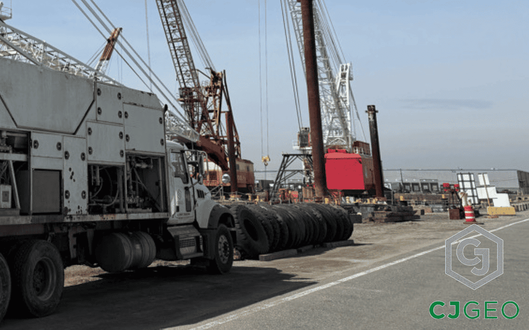 CJGeo cellular grout plant sitting on a pier next to barge mounted cranes in front of a blue sky.