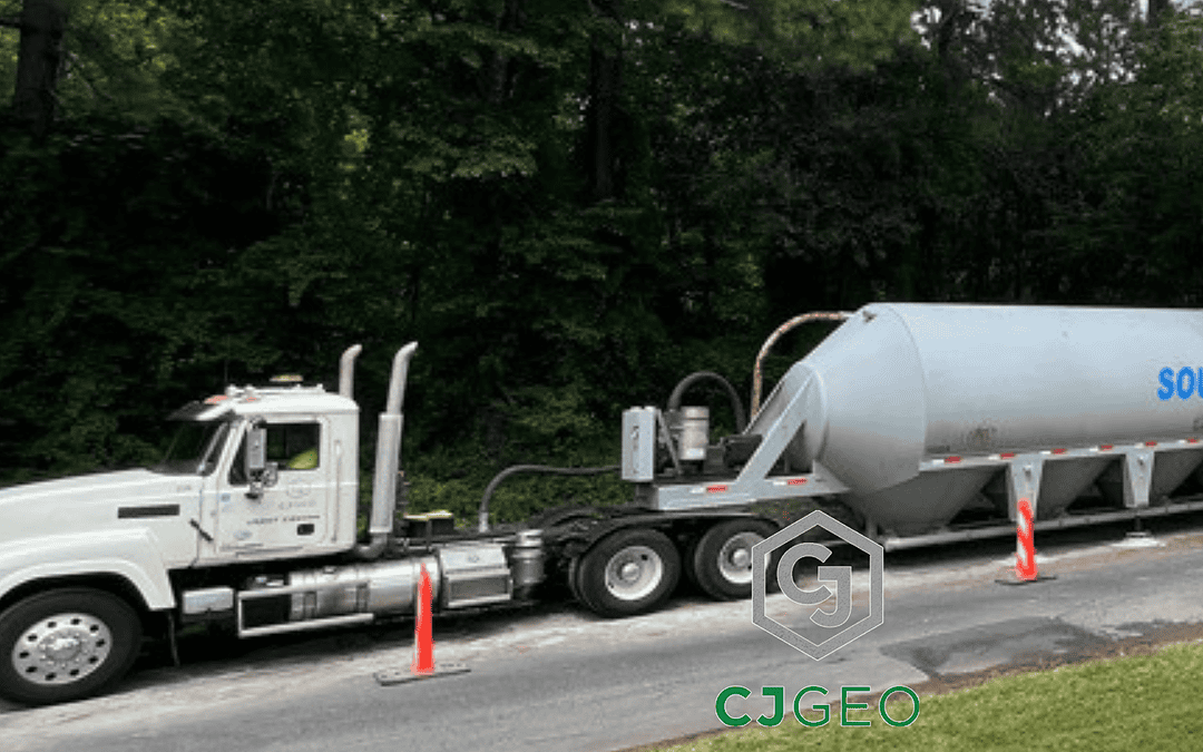 a semi, cement pig, batch plant and pickup truck on a roadside pipe abandonment jobsite