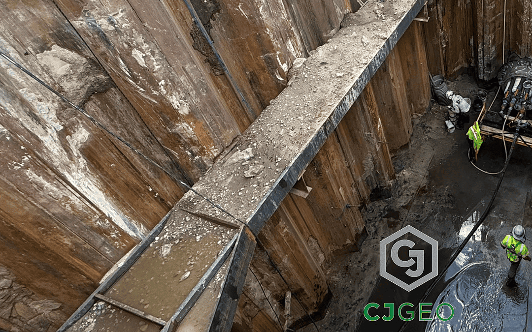two CJGeo workers at the base of a sheet pile shaft with a microtunnel containing electrical conduits in preparation for thermal grouting operations.