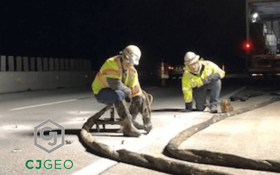 two workers injecting polyurethane grout under concrete pavement at night