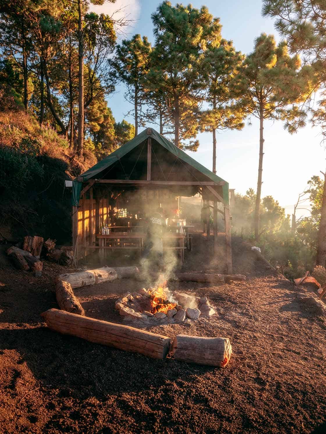Fire pit and covered dining area at OX Expeditions campsite on Acatenango during golden hour