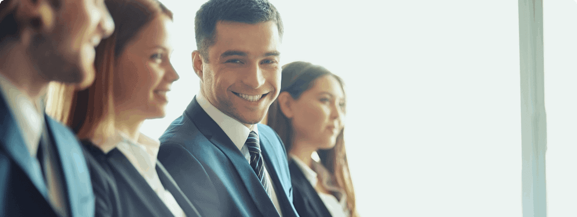 Smiling businessman in suit with colleagues.