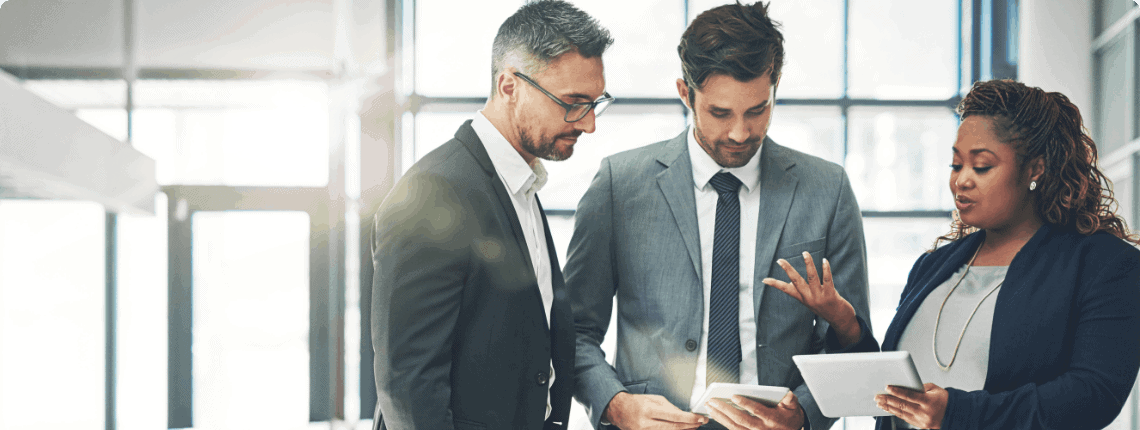 Three businesspeople discussing work in an office.