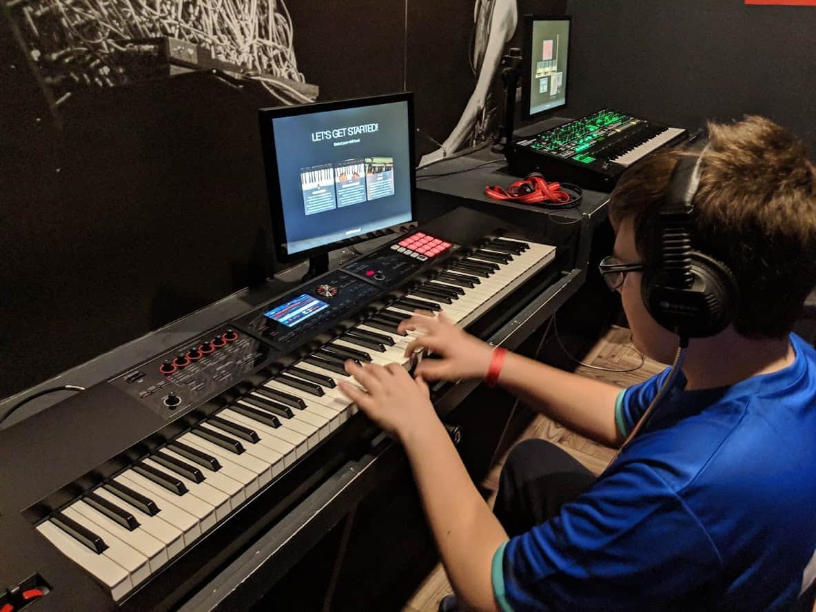 Teenage boy wearing headphones playing a keyboard